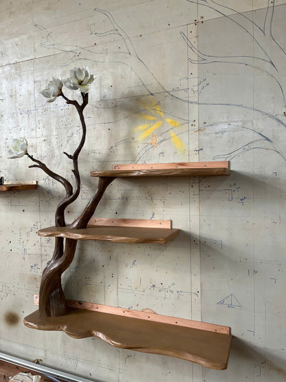 Wooden shelves with a natural branch design against a textured wall.